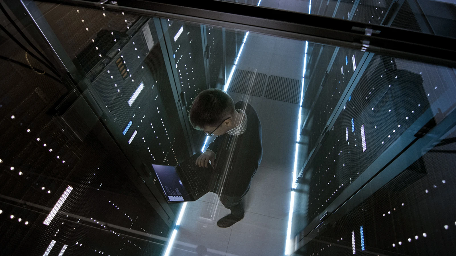 person in data center on laptop