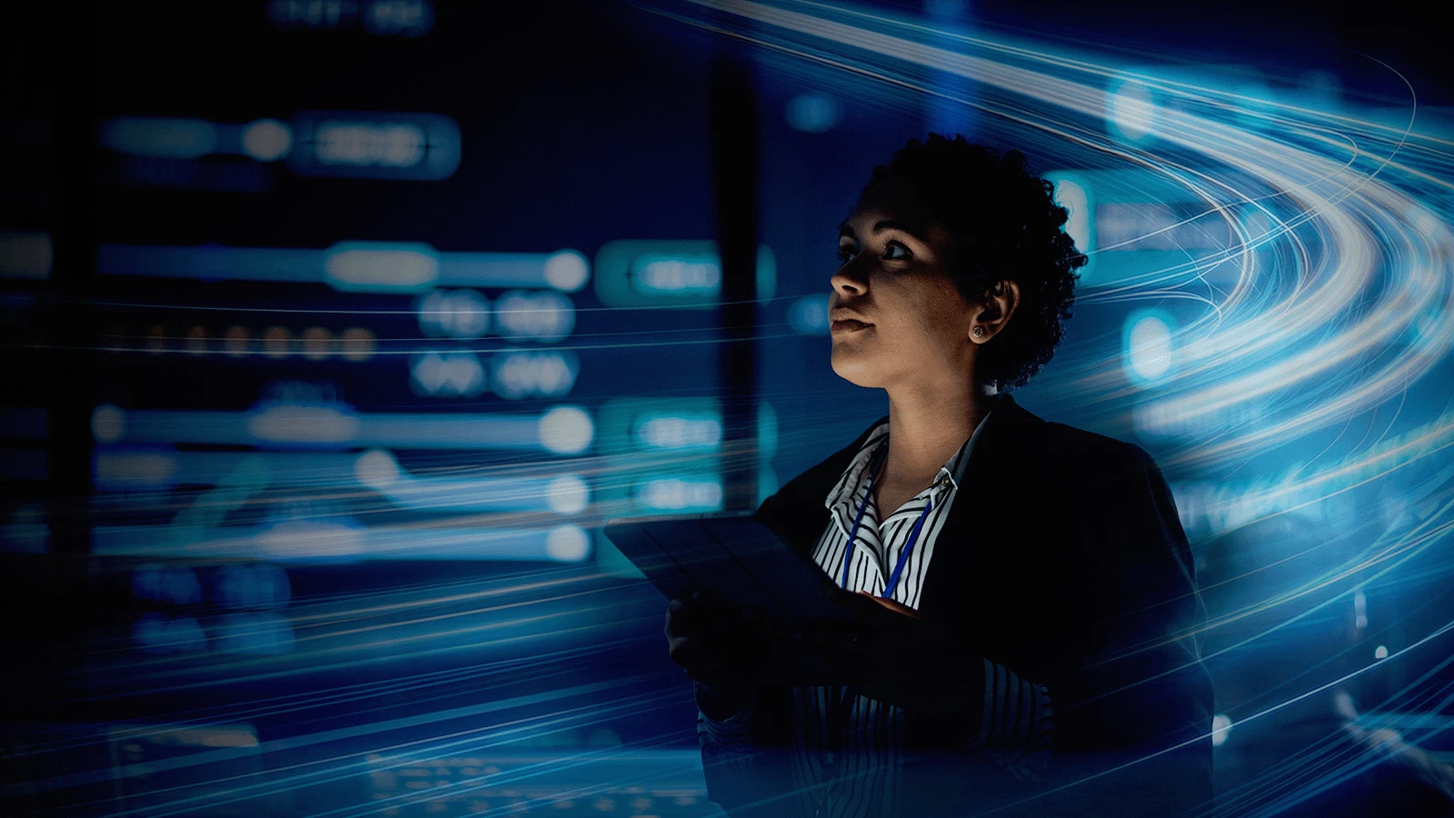 woman holding tablet looking up at server room with light swirls