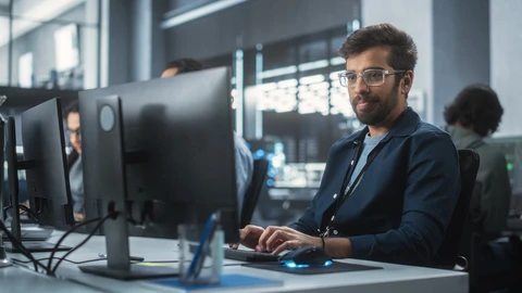Man at computer typing up issue for customer.