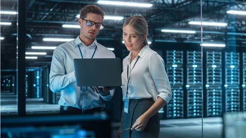 2 people reviewing data over a laptop