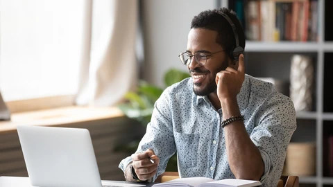 Happy person on headset in front of laptop